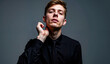 © YuriDA Art - a man in a black shirt and tie posing for a picture against a grey background. He appears to be a songwriter, with a confident and determined expression on his face.