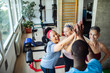 © Marko Geber - Senior women and a fitness instructor joining hands in a gym