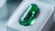 © Yuliia - Green transparent capsule with glittering particles inside resting in white packaging, representing pharmaceutical innovation or nutritional supplement for health industry.