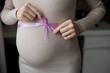 © jozzeppe777 - pregnant belly in dress with violet ribbon