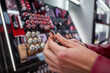 © pedro - Woman buying make up at cosmetics section in store. Customer shopping beauty products. Choosing lipstick from shelf and selection. Using tester.