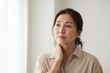 © Anna - Thoughtful middle-aged Asian woman looking away with a pensive expression. Midlife changes and health concept. Representing menopause and self-care