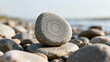 © li - A smooth riverbed stone with concentric grooves resting among pebbles in soft daylight. travel magazines, destination branding, designed for outdoor magazines and nature guides.