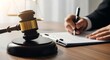 © Pixel Stone - Lawyer signing legal documents with gavel and scales of justice on desk