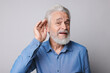 © New Africa - Senior man with hearing problem on light grey background