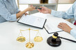 © Freedomz - Male lawyer consulting and discussion to businesswoman client at law firm in office, Judge gavel with scales of justice