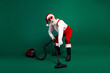 © deagreez - Santa Claus in festive costume vacuuming with style on a bright green background to bring holiday cheer and humor