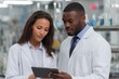 © Jaroon - Focused Collaboration: Scientists in lab coats intently discuss data on a tablet within a high-tech laboratory setting, embodying the spirit of scientific collaboration and research.