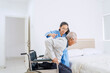© Creativa Images - Professional Nurse Helping Elderly Man Transfer from Wheelchair to Bed