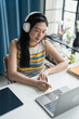 © Charlie's - Online Tutoring Asian Girl in Headphones Engaged in Online Class with Laptop education writing homework study e-learning preparing for exam