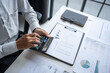 © Charlie's - Businessman Calculating Finances with Calculator in Modern Office.