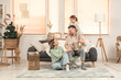 © Pixel-Shot - Happy parents and their little daughter sitting on sofa in winter day at home