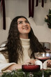 © Sergey - Smiling young woman enjoying festive gathering during winter celebration
