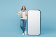 © ViDi Studio - Full body young woman wear sweater scarf big huge blank screen mobile cell phone point finger up isolated on plain blue background studio. Healthy lifestyle ill disease treatment cold season concept.