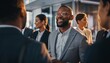 © Rifqi - Smiling african american man enjoying a social gathering with business colleagues, concept for networking event, corporate party and professional development meeting