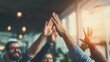 © D.APIWAT - Colleagues highfiving, celebrating business success in modern sunlit office, embodying effective team collaboration.