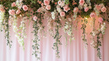 Pastel pink wedding backdrop decorated with cascading white and pink flowers and green leaves, creating romantic and elegant floral arrangement for special occasions