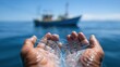 © OleksandrZastrozhnov - Hands holding fishing net on tranquil ocean with boat in background
