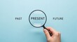 © Pixel Stone - Magnifying glass focusing on the present between past and future on blue