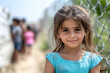 © Наталья Лазарева - Refugee girl,forced migrant,standing near wire fence,smiling despite difficult conditions,concept child resilience,children resilience during migration ,life of children in refugee camp,hope,future