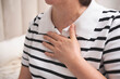 © Di_Ilikaeva - Portrait of adult woman with hand on heart area suffering from chest pain at home.