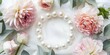 © Maker - Elegant pearl necklace nestled amongst delicate pastel flowers and greenery
