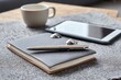 © Svitlana - Still life of a notepad, pen, rings, tablet computer and cup on a gray textured surface, home office setup for work