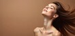 © Maryna - Young woman with flowing brunette hair poses with head tilted back, eyes closed. Her skin glows under studio lights against plain brown backdrop, conveying health and beauty. Scene suggests haircare.