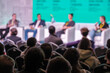 © Anton Gvozdikov - Panel discussion at conference stage with speakers and audience, vibrant backdrop, professional atmosphere, learning and networking