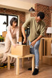 © DC Studio - African american boyfriend sealing cardboard box with clear tape while caucasian girlfriend assists during moving day. Diverse couple prepares for relocation, packing items into cartons in apartment.