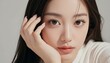 © Yka - 白背景で頬に手を当てて見つめる女性