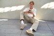 © Studio Sincère/Stocksy - Young Man Enjoys Casual Moments While Texting Outdoors