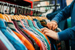 © Dani Nahuel/Stocksy - Close-up of shopper’s hands browsing colorful shirts