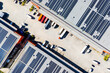 © Yic Ma/Stocksy - Aerial top view of logistics warehouse with solar rooftops and trucks