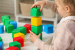 © Pixel-Shot - Cute little girl playing with plastic cubes at table in children's room, closeup
