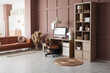© Pixel-Shot - Interior of modern office with workplace, shelving unit and sofa near brown wall