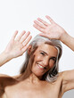 © Leandro Crespi/Stocksy - Smiling Mature Woman With Gray Hair Shields Her Face