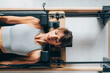 © OchreOchre/Stocksy - Woman Exercising on a Pilates Reformer in a Fitness Studio