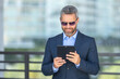 © Volodymyr - Urban entrepreneur reviewing business strategy. Business man outdoors on tablet. Businessman using tablet outside. Businessman checking finance data. Rich business man reviewing contract on tablet.