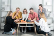 © Volodymyr - Group of friends enjoying pizza together in a living room. Happy friends share pizza and laughter. Friendship and warmth. Friends grabs a slice of pizza. Weekend with good company and tasty pizza.