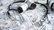 © Jokiewalker - Medicine bottles and stethoscope on money suggesting drug cost inflation, expensive prescriptions and financial impact on health care.