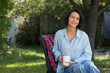 © ulza - portrait of a cheerful middle aged woman with a cup of tea in the garden about her home on a summer. concept without stress. mental health.  Mindfulness and feel-good moments.