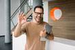 © BusinessClass by W61 - Confident business consultant smiling with tablet making ok gesture indoors