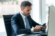 © BusinessClass by W61 - Businessman working with smartphone at desk in modern office
