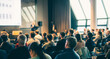 © kasto - Speaker giving a talk in conference hall at business event. Rear view of unrecognizable people in audience at the conference hall. Business and entrepreneurship concept