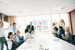 © deagreez - Diverse professional team celebrates success during an office presentation showcasing teamwork and collaboration in a modern workplace