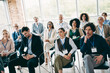 © deagreez - Professionals attentively interacting during a corporate conference in a modern office space highlighting teamwork and discussions