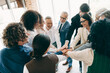 © deagreez - Team of business professionals collaborating and supporting each other in a corporate office environment, emphasizing teamwork