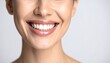 © Daun - Close-up view of a smiling woman's mouth, showcasing healthy, bright white teeth and glossy, nude-toned lips