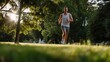 © Phloenjai - Dynamic outdoor runner jogging through lush park landscape with sunlight filtering through trees showcasing fitness exercise health motivation and active lifestyle